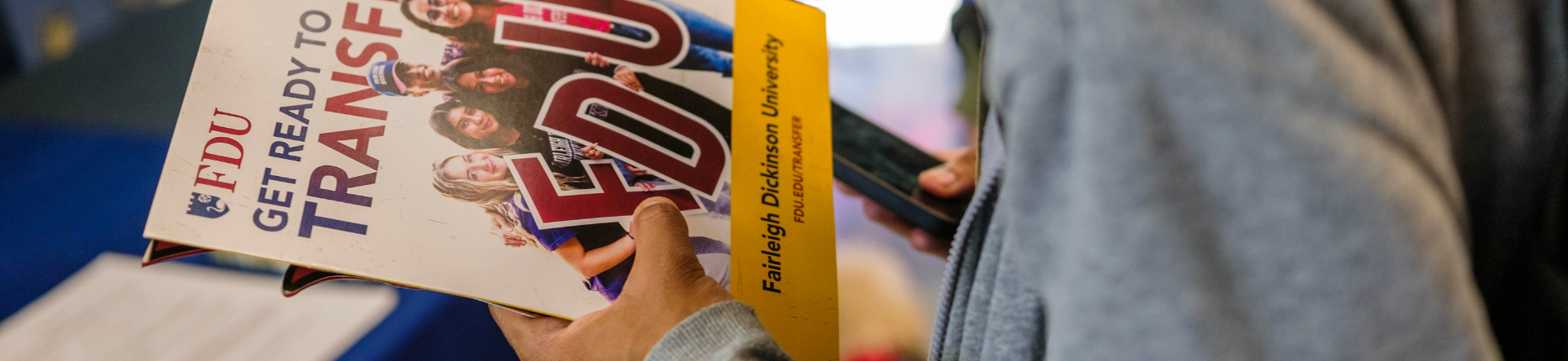 student holding a brochure